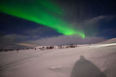 Scenic view of snowcapped landscape against sky at night