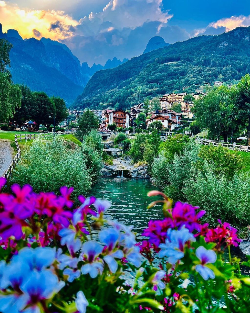 plant, flower, flowering plant, mountain, beauty in nature, nature, landscape, scenics - nature, environment, sky, mountain range, water, architecture, land, freshness, building, cloud, lake, meadow, built structure, travel destinations, building exterior, no people, tree, travel, multi colored, tranquility, rural scene, outdoors, springtime, house, blue, city, growth, tranquil scene, summer, field, tourism, valley, village, residential district, idyllic, green, town, day
