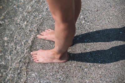 Low section of child standing on beach