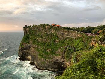 Scenic view of cliff by sea against sky