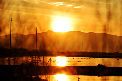 Scenic view of lake against sky during sunset