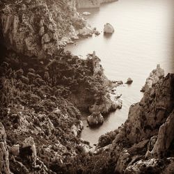 Rock formation by river against sky