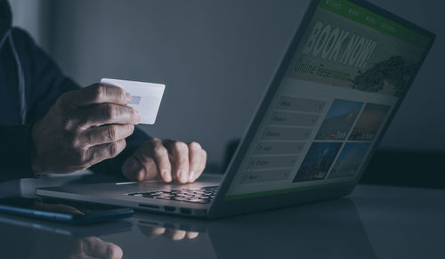 Midsection of woman using laptop on table