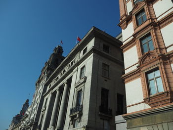 Low angle view of buildings against clear blue sky