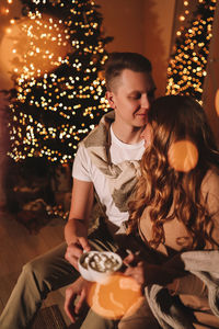 A romantic couple in love celebrates christmas holidays and new year in a cozy house at night