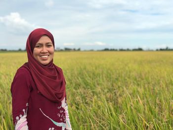 Portrait of smiling woman standing on field