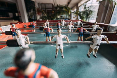 From above closeup of tabletop soccer game with figurines of players placed in contemporary recreation area