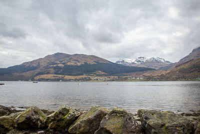 Calm lake against rocky mountain range