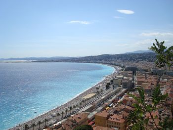 High angle view of sea by city against sky