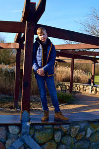 Man standing by railing against sky