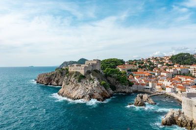 Scenic view of sea and buildings against sky