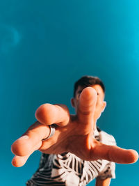 Low angle view of man against blue background