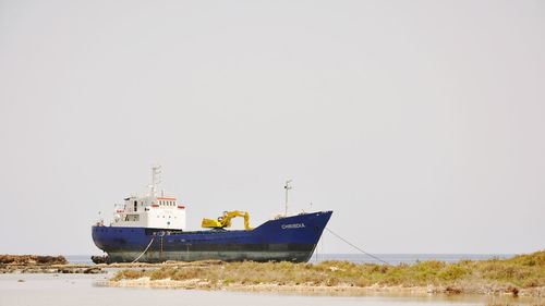 Ship moored on sea against clear sky