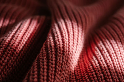 Knitted texture of a pink sweater or scarf close-up.