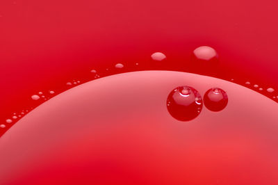 Close-up of drop falling on red water