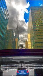 Modern buildings against cloudy sky