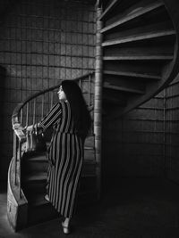 Portraits-  woman standing against wall on a spiral staircase