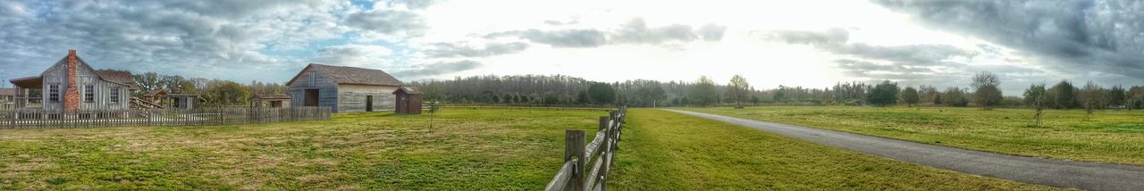 View of grassy field against cloudy sky