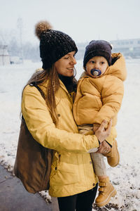 Female friends standing on snow during winter