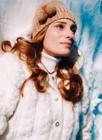 Portrait of young woman lying down in snow