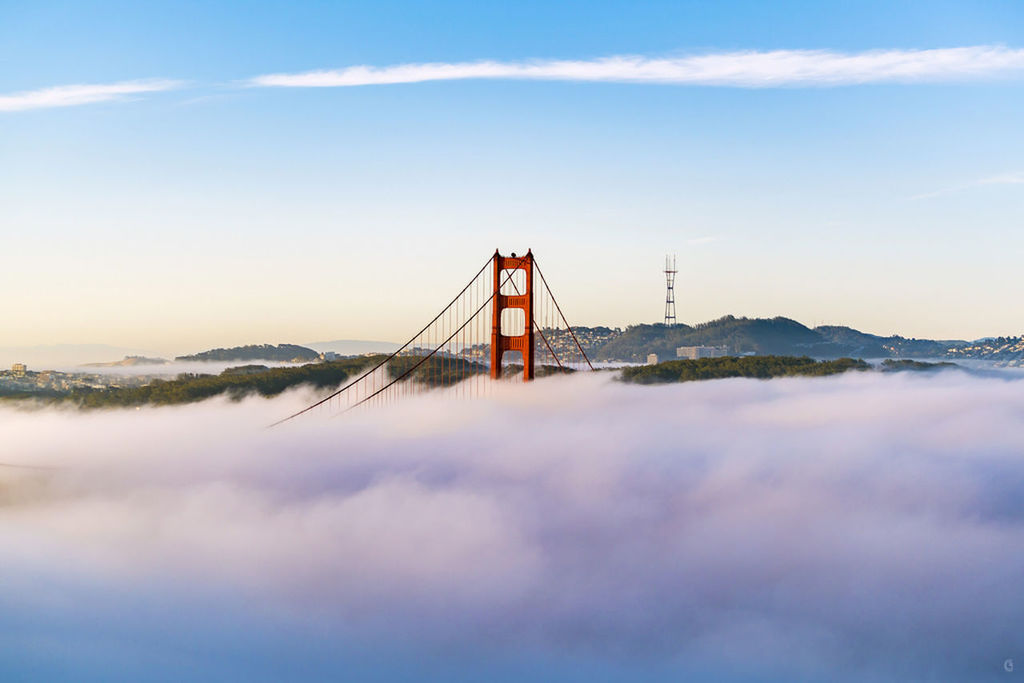 suspension bridge, bridge - man made structure, built structure, water, architecture, connection, golden gate bridge, waterfront, international landmark, sky, travel, cloud - sky, scenics, sea, blue, nature, tourism, travel destinations, tranquil scene, beauty in nature, bay of water, famous place, tranquility, engineering, day, outdoors, mountain, in front of, foggy, san francisco bay, mountain range, no people