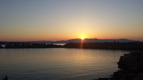 Scenic view of silhouette mountains against clear sky during sunset