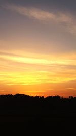 Scenic view of silhouette landscape against orange sky