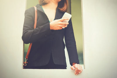 Midsection of woman using mobile phone