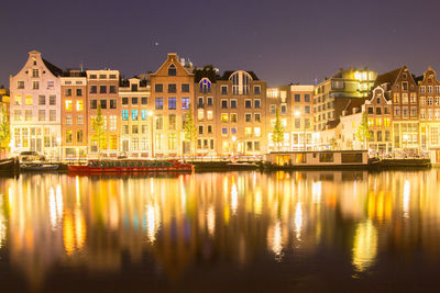 Reflection of illuminated buildings in river at night