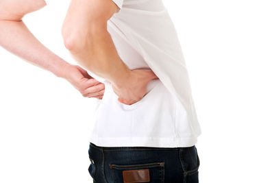 Midsection of man with backache standing over white background