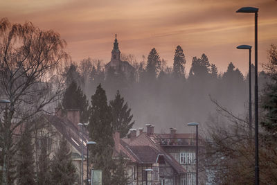 Panoramic view of trees and buildings against sky during sunset