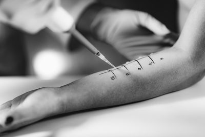 Midsection of doctor holding thermometer