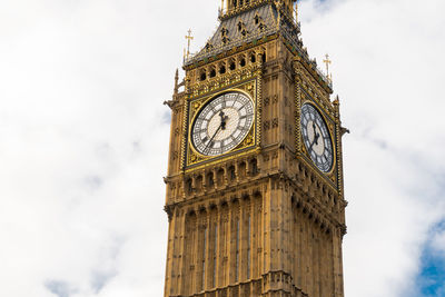 Low angle view of clock tower against cloudy sky