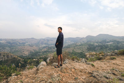 Young man standing with a background of valley 