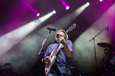 Low angle view of playing guitar at music concert