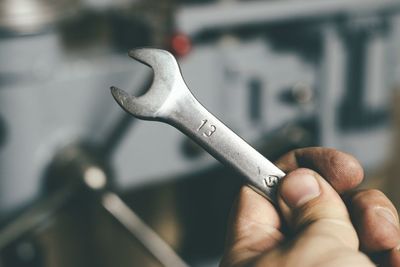 Cropped hand of man repairing metal