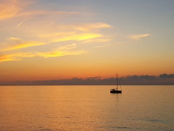 Silhouette sailboat sailing on sea against sky during sunset