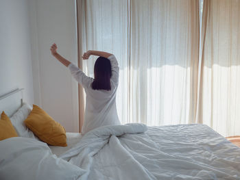 Rear view of man on bed at home