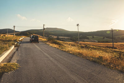 Road by mountain against sky