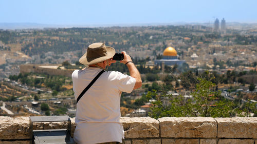 Rear view of man standing on retaining wall