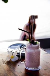 Close-up of drink on table with woman in background