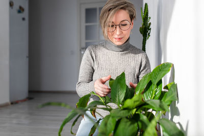 Young woman holding mask at home