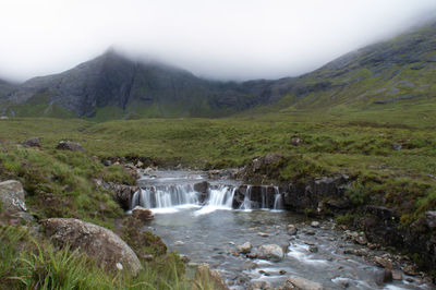 Scenic view of waterfall against sky