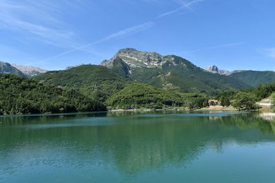 Scenic view of lake and mountains against blue sky