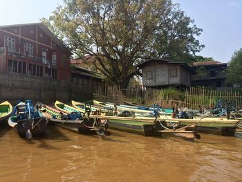 Boats moored on shore against sky