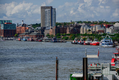 Sea by buildings against sky in city