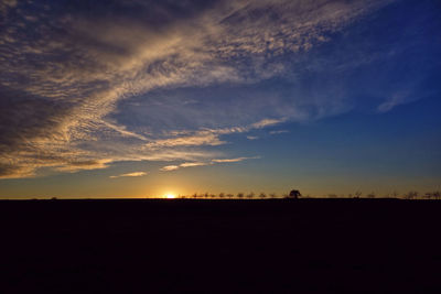 Scenic view of silhouette land against sky at sunset