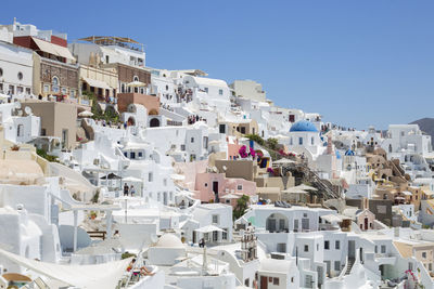 Buildings in city against clear blue sky