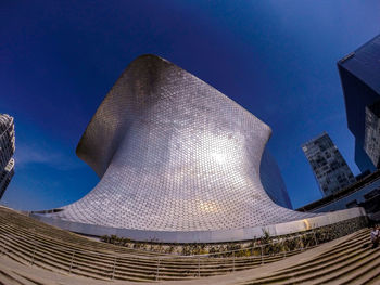 Low angle view of modern buildings against blue sky