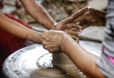 Cropped hands making pot